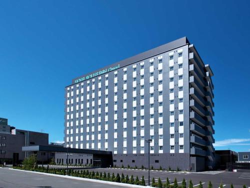 a large white building with a lot of windows at Hotel Route Inn Grand Misawa-EAST COURT in Misawa