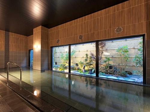 a swimming pool with an aquarium in a building at Hotel Route Inn Grand Misawa-EAST COURT in Misawa