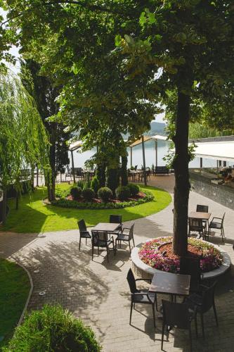 a park with tables and chairs and a tree at Romantique Veles Hotel in Veles