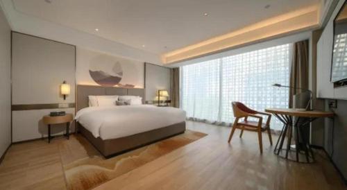 南寧市にあるEcheng Hotel Nanning the Mixc Conventionのベッドとテーブルと机のある寝室