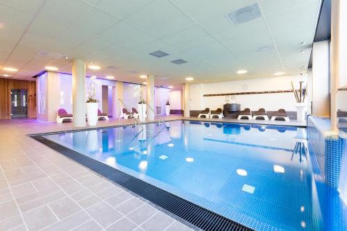 - une grande piscine dans une chambre d'hôtel dans l'établissement Fletcher Wellness-Hotel Stadspark, à Berg-op-Zoom