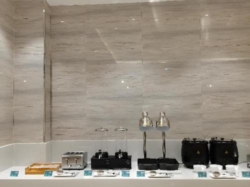 a table with glasses and other items on it at City Comfort Inn Suichuan County Government Pedestrian Street in Suichuan