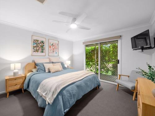 a bedroom with a bed and a tv and a window at River Retreat in Yarrawonga