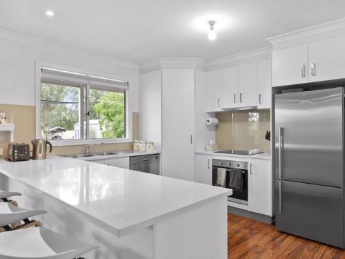 a white kitchen with a large white counter top at River Retreat in Yarrawonga