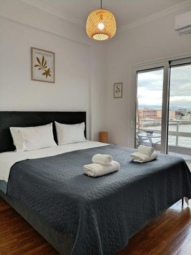 a bedroom with a large bed with two towels on it at Beach Retreat in town in Korinthos