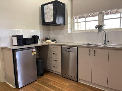a kitchen with a stainless steel refrigerator and a sink at 1839 Cottages in Willunga