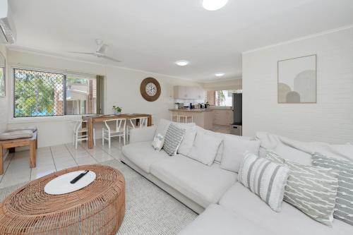 a living room with a white couch and a table at Saltz on The Strand in North Ward