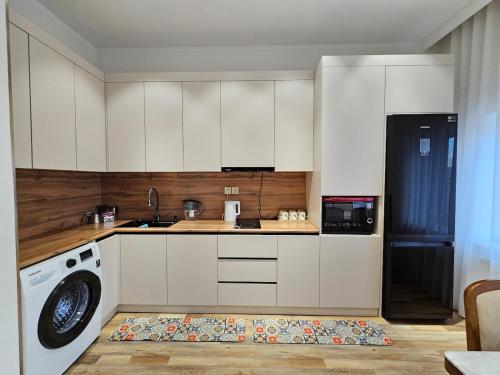a kitchen with white cabinets and a washing machine at Rooftop 1 Bedroom, Near City Center in Ulaanbaatar