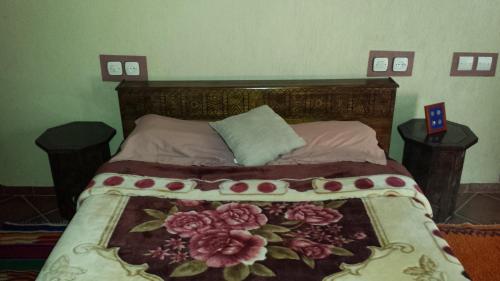 a bedroom with a bed with a floral bedspread at Taddart Aglou in Zaouit Aglou