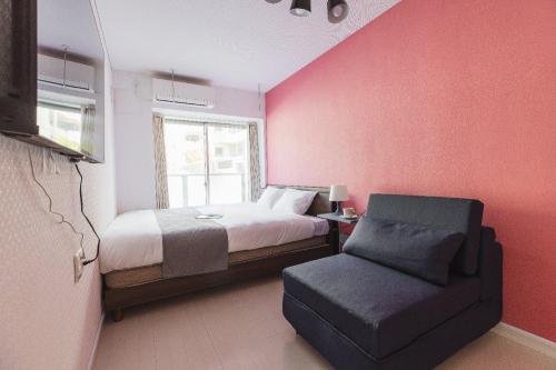 a bedroom with a bed and a chair and a window at VILLA SAKURA Hatanodai II in Tokyo