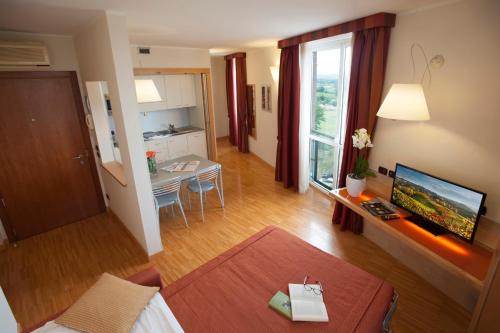 a living room with a bed and a table and a television at AlbaResidence Masera26 in Alba