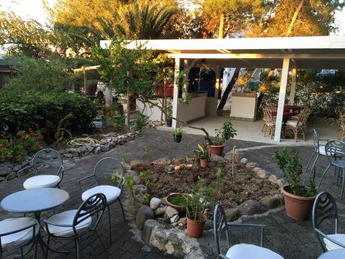 a patio with tables and chairs in a garden at Hotel Le Viole in San Domino