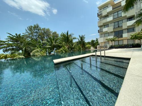 a swimming pool in front of a building at By The Sea with Side Seaview #363A in Batu Ferringhi