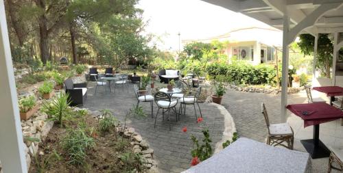 a patio with tables and chairs in a garden at Hotel Le Viole in San Domino