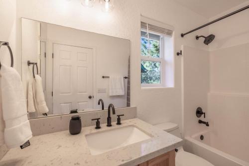 a white bathroom with a sink and a mirror at Peak Pursuit Jacuzzi, Sauna, Game Room, Renovated in Sugarloaf