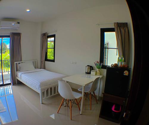 Un dormitorio con una cama y una mesa y sillas. en Modern House CNX, en Chiang Mai