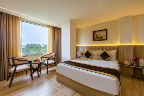 a hotel room with a bed and a table and a window at Dahabi Venue Premium- Free Airport Pick up or Drop in New Delhi
