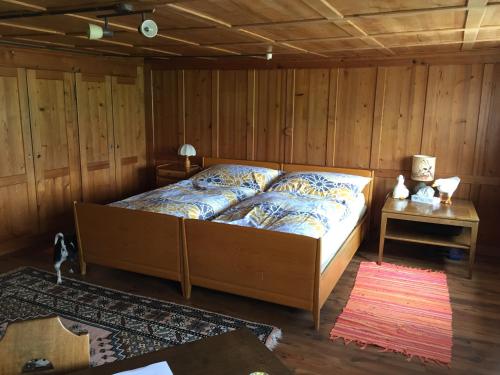 a bedroom with a bed in a room with wooden walls at Wohlfühloase für Mensch und Hund in Uzwil
