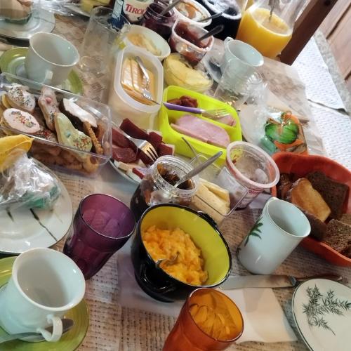 Una mesa cubierta con platos y cuencos de comida en Casa suíça luxo-suite nr2- para 4 pessoas, en Pomerode