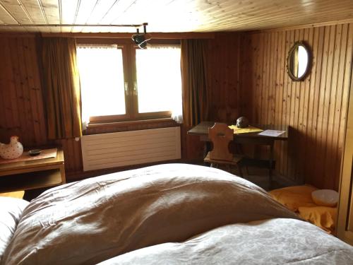 a bedroom with a bed and a desk and a window at Wohlfühloase für Mensch und Hund in Uzwil