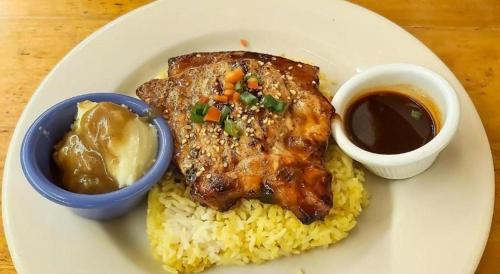 a plate of food with rice and meat and sauce at Dino Residences in Dumaguete