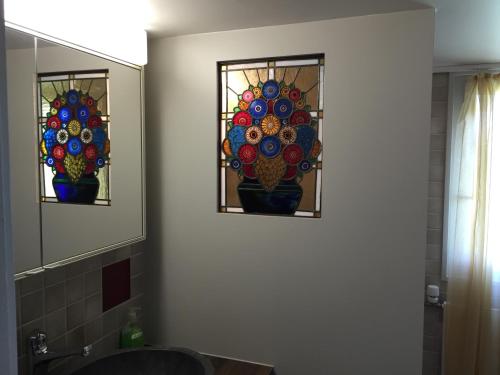 two stained glass windows in a bathroom with a sink at Wohlfühloase für Mensch und Hund in Uzwil