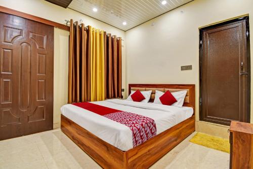 a bedroom with a large bed and a wooden door at Hotel O The Honey Guest House in Haldwāni