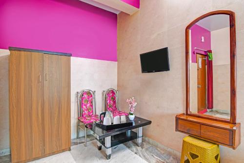 a bathroom with pink walls and a vanity with mirrors at Super Hotel O Rishra Railway Station Formerly Green Guest House in Khardah