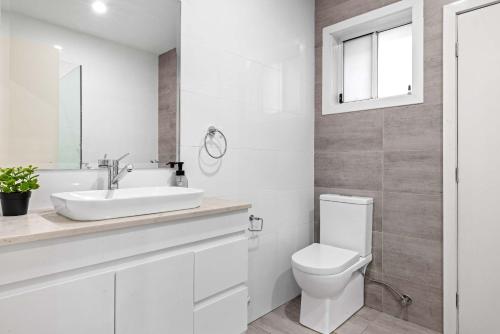 ein weißes Badezimmer mit Toilette und Waschbecken in der Unterkunft Sleek & Comfortable Double Room at Revesby with Shared Amenities in Revesby