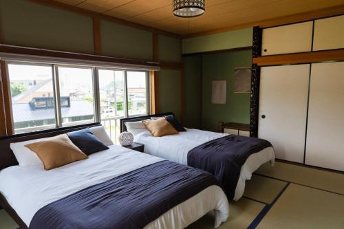 a bedroom with two beds and a window at mion in Kyonan