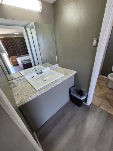 a bathroom with a sink and a mirror at Lamplighter Inn Independence in Independence