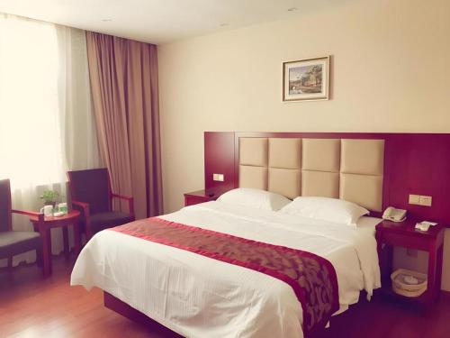 a hotel room with a large bed in a room at GreenTree Inn Jiangxi Shangrao Qianshan Ehu Avenue Express Hotel in Shangrao
