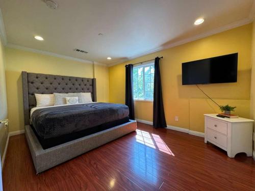 a bedroom with a bed and a flat screen tv at 3 bedroom apartment by the MrC Hotel and 5 minutes to Rodeo Drive WiFi TV Patio walk to restaurants in Los Angeles