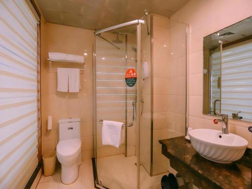 a bathroom with a toilet and a sink and a shower at GreenTree Inn MaAnshan Economic Development District Hongqi South Road Express Hotel in Ma'anshan