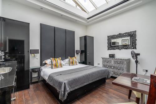 a bedroom with a bed and a sink and a mirror at Strozzi Palace Suites by Mansley in Cheltenham