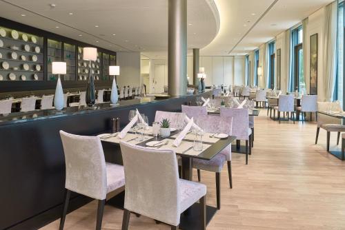 a dining room with purple chairs and tables at Dorint Hotel Frankfurt/Oberursel in Oberursel