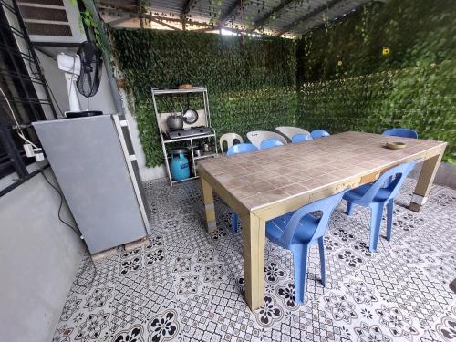 - une table en bois et des chaises bleues sur la terrasse dans l'établissement Hundred Islands lucky One Transient 3mins walk fr wharf, à Alaminos