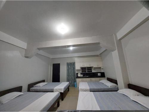 une chambre avec trois lits et une cuisine dans l'établissement Hundred Islands lucky One Transient 3mins walk fr wharf, à Alaminos
