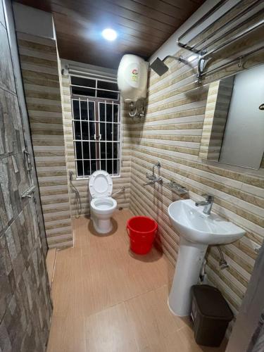 a bathroom with a toilet and a sink at Anagh Guest House in Shillong