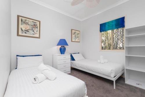 una camera da letto con due letti e una finestra di Bird and Leaf Cottage a Brisbane