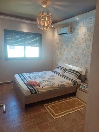 a bedroom with a bed and a chandelier at Très beau appartement avec piscine in Casablanca