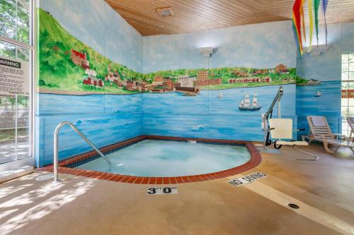 a hot tub in a room with a painting on the wall at Comfort Suites in Marquette