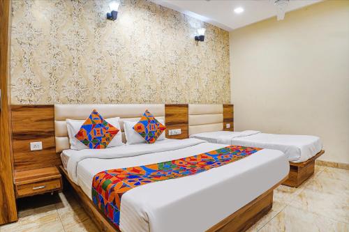 a bedroom with two beds and a wall at FabHotel Shri Vilas in Bhopal
