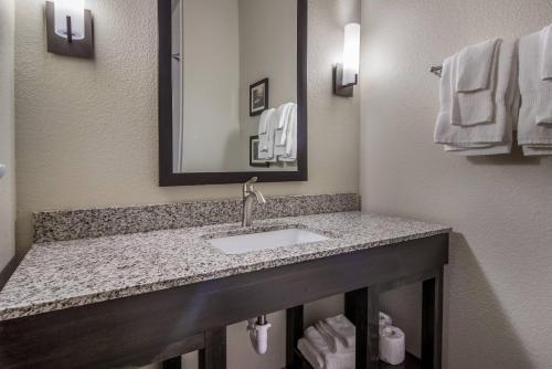 a bathroom with a sink and a mirror and towels at Comfort Suites Brunswick - Cleveland Southwest in Brunswick