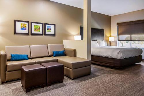 a hotel room with a bed and a couch at Comfort Suites Wooster near University Campus in Wooster