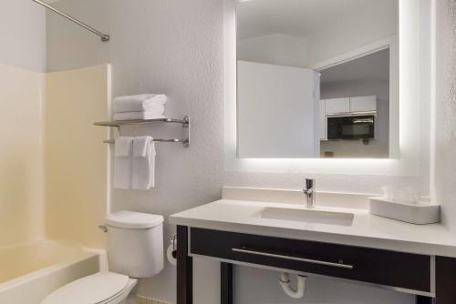Un baño con lavabo, inodoro y espejo. en MainStay Suites Denver Tech Center, en Centennial