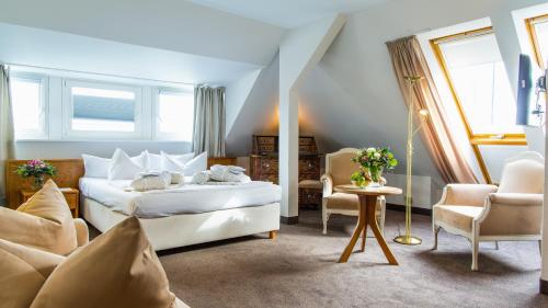 1 dormitorio con 1 cama, mesa y sillas en Hotel Holsteiner Hof GmbH, en Timmendorfer Strand