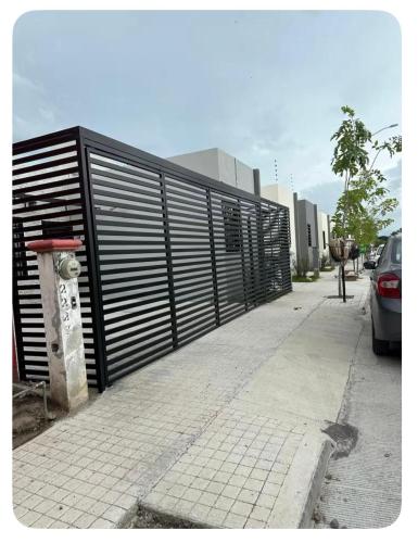 a black gate on a sidewalk next to a parking lot at Casa Andares in Colima