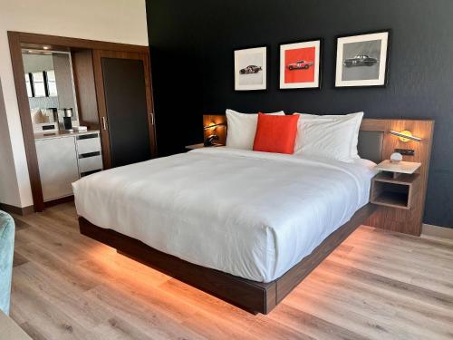 a bedroom with a large white bed with orange pillows at Cambria Hotel Northlake Conference Center - Roanoke in Northlake
