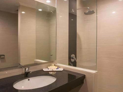 a bathroom with a sink and a glass shower at Star Hotel in Pontianak